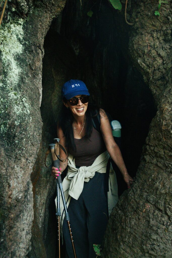 Hiker emerges from a cave on Acatenango Volcano, wearing a blue cap.