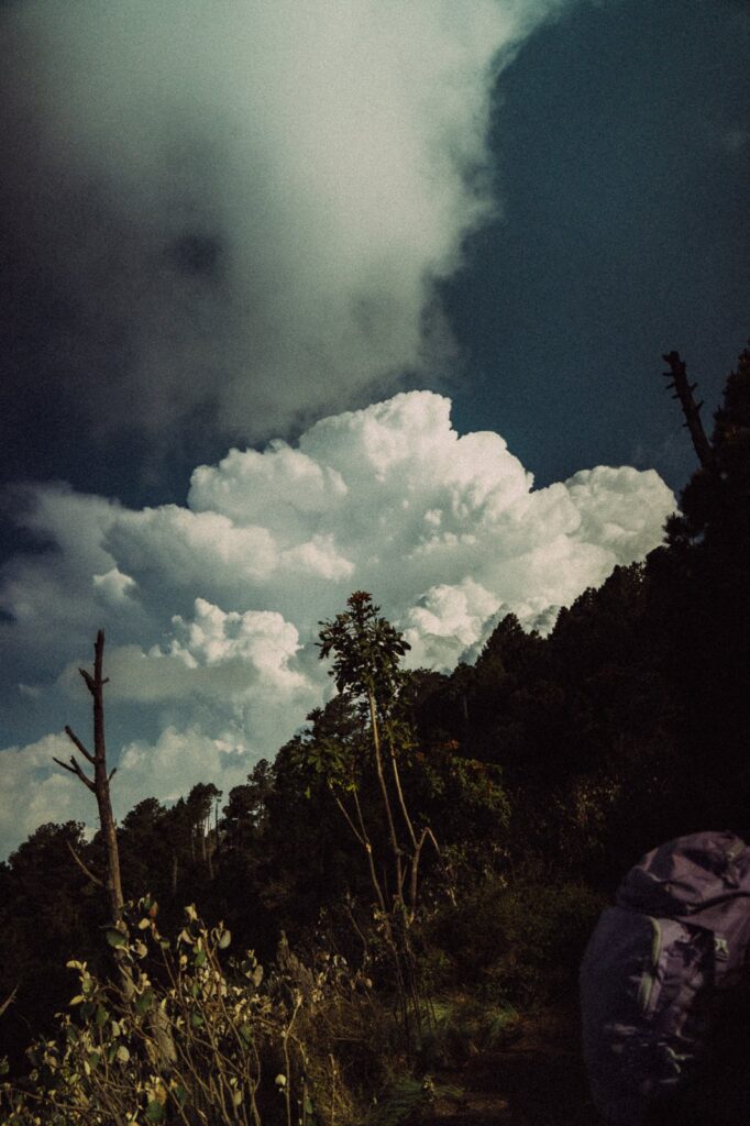 Dramatic clouds over Acatenango Volcano's lush, dark slopes. Hiking with a backpack.
