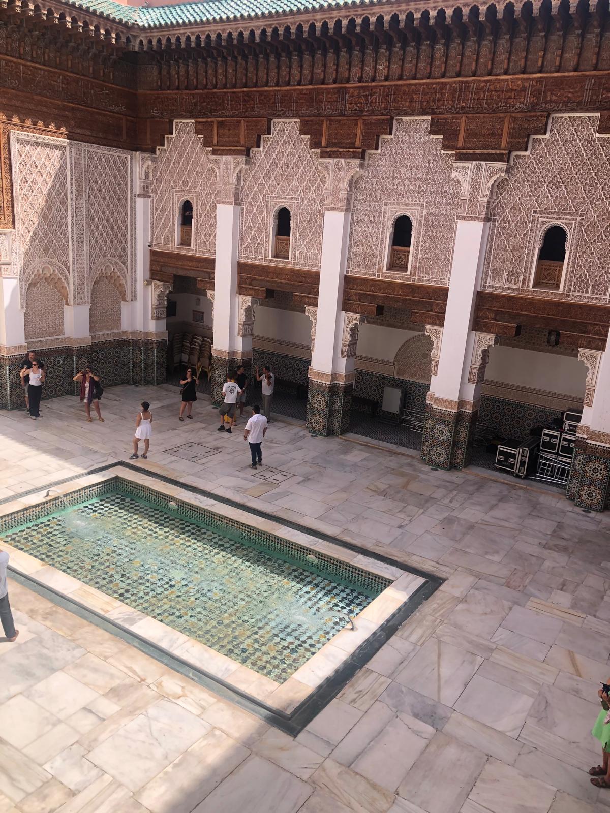Courtyard of a Moroccan riad with a central fountain and intricate tilework.